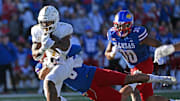 Oct 7, 2023; Lawrence, Kansas, USA; UCF Knights running back RJ Harvey (7) runs up field against Kansas Jayhawks linebacker Taiwan Berryhill Jr. (6) during the second half at David Booth Kansas Memorial Stadium. Mandatory Credit: Peter Aiken-Imagn Images