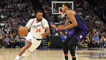 Apr 11, 2025; Sacramento, California, USA; Los Angeles Clippers guard Norman Powell (24) dribbles against Sacramento Kings forward Keegan Murray (right) during the fourth quarter at Golden 1 Center. Mandatory Credit: Darren Yamashita-Imagn Images