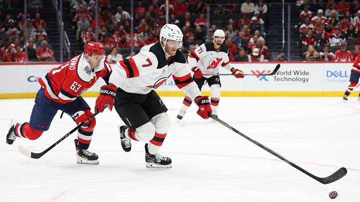 New Jersey Devils defenseman Dougie Hamilton (7) skates with the puck as Washington Capitals left wing Ivan Miroshnichenko (63) chases: Geoff Burke-Imagn Images