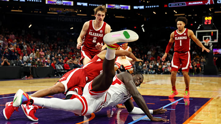 Dec 20, 2023; Phoenix, Arizona, USA; Arizona Wildcats center Oumar Ballo (11) falls to the court during the second half of the game against the Alabama Crimson Tide in the Hall of Fame Series at Footprint Center. Mandatory Credit: Mark J. Rebilas-Imagn Images