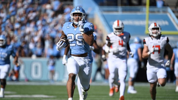 Nov 4, 2023; Chapel Hill, North Carolina, USA; North Carolina Tar Heels running back Omarion Hampton (28) runs as Campbell Fighting Camels linebacker Monchovia Gaffney (4) and linebacker Taylor Behl (17) defend in the first quarter at Kenan Memorial Stadium. Mandatory Credit: Bob Donnan-USA TODAY Sports