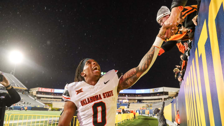 Oct 21, 2023; Morgantown, West Virginia, USA; Oklahoma State Cowboys running back Ollie Gordon II (0) celebrates with fans after defeating the West Virginia Mountaineers at Mountaineer Field at Milan Puskar Stadium. Mandatory Credit: Ben Queen-USA TODAY Sports