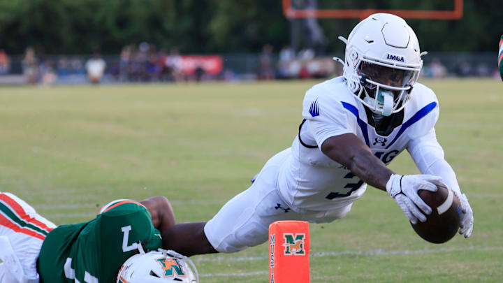 IMG Academy's Eric McFarland (3) scores a rushing touchdown against Mandarin's Tamajh Mitchell (7) during the first quarter of a high school football matchup at Mandarin High School, Friday, Sept. 19, 2025, in Jacksonville, Fla. The IMG Academy Ascenders defeated the Mandarin Mustangs 57-7.