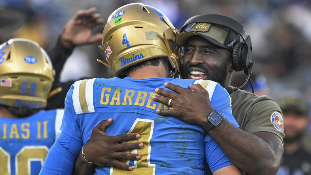 Nov 30, 2024; Pasadena, California, USA; UCLA Bruins head coach DeShaun Foster hugs quarterback Ethan Garbers (4) as time runs out during a Bruins victory over the Fresno State Bulldogs at Rose Bowl. Mandatory Credit: Robert Hanashiro-Imagn Images Nov 30, 2024; Pasadena, California, USA; UCLA Bruins head coach DeShaun Foster hugs quarterback Ethan Garbers (4) as time runs out during a Bruins victory over the Fresno State Bulldogs at Rose Bowl. Mandatory Credit: Robert Hanashiro-Imagn Images