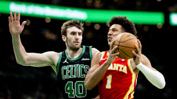 Jalen Johnson #1 of the Atlanta Hawks drives against Luke Kornet #40 of the Boston Celtics.