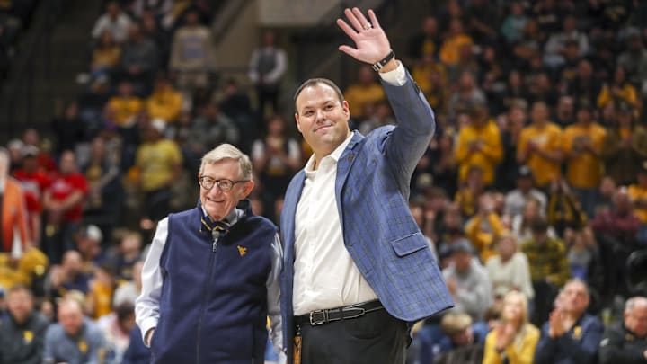 Dec 18, 2022; Morgantown, West Virginia, USA; West Virginia University President Gordon Gee welcomes new West Virginia Mountaineers Athletic Director Wren Baker during the first half against the Buffalo Bulls at WVU Coliseum. Mandatory Credit: Ben Queen-Imagn Images