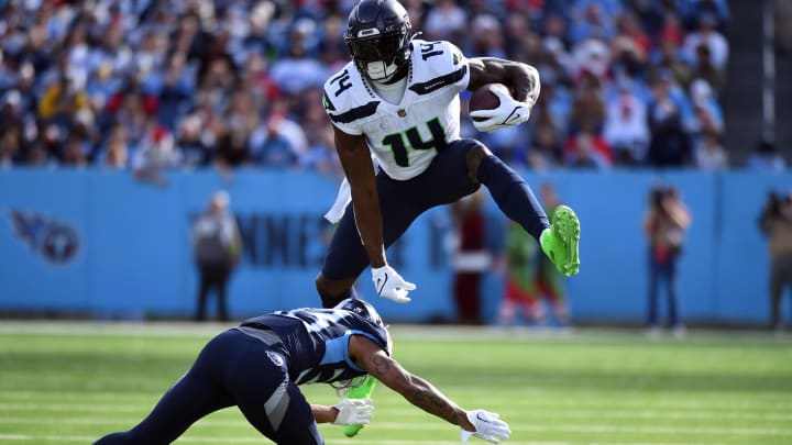 Dec 24, 2023; Nashville, Tennessee, USA; Seattle Seahawks wide receiver DK Metcalf (14) jumps over a tackle attempt from Tennessee Titans cornerback Eric Garror (33) during the first half at Nissan Stadium.