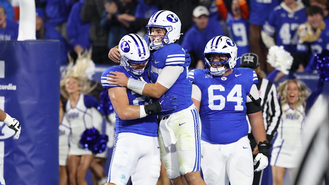 BYU Cougars quarterback Bear Bachmeier (middle) celebrates scoring a touchdown against the Texas Christian University Horned Frogs with tight end Carsen Ryan (20) and offensive lineman Kyle Sfarcioc (64) during the second quarter at LaVell Edwards Stadium. 