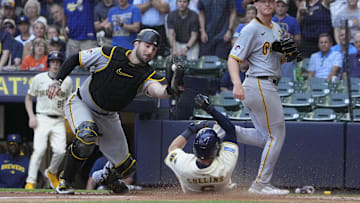Milwaukee Brewers outfielder Isaac Collins (6) slides under the tag of Pittsburgh Pirates catcher Joey Bart (14) in the fourth inning at American Family Field on Wednesday.