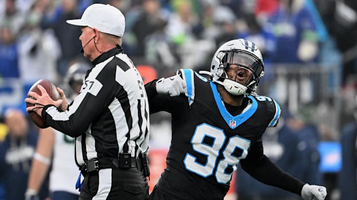 Dec 28, 2025; Charlotte, North Carolina, USA; Carolina Panthers linebacker D.J. Wonnum (98) tosses the ball to referee Carl Cheffers (51) and reacts after sacking Seattle Seahawks quarterback Sam Darnold (not pictured) during the fourth quarter at Bank of America Stadium. Mandatory Credit: Bob Donnan-Imagn Images