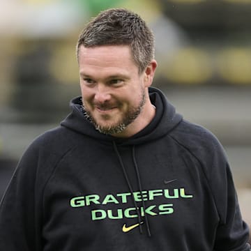 Oct 25, 2025; Eugene, Oregon, USA; Oregon Ducks head coach Dan Lanning encourages players during warm-ups before a game against the Wisconsin Badgers at Autzen Stadium. The Ducks are wearing uniforms celebrating the Grateful Dead. Mandatory Credit: Troy Wayrynen-Imagn Images