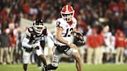 Nov 12, 2022; Starkville, Mississippi, USA; Georgia Bulldogs quarterback Stetson Bennett (13) runs the ball againstMississippi State Bulldogs safety Collin Duncan (19) during the second quarter at Davis Wade Stadium at Scott Field. Mandatory Credit: Matt Bush-Imagn Images