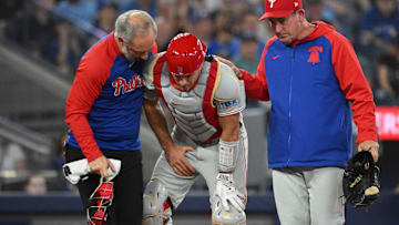 Jun 4, 2025; Toronto, Ontario, CAN;  Philadelphia Phillies catcher J.T. Realmuto (10) is helped off the field after being injured by a tip foul against the Toronto Blue Jays in the ninth inning at Rogers Centre. Mandatory Credit: Dan Hamilton-Imagn Images