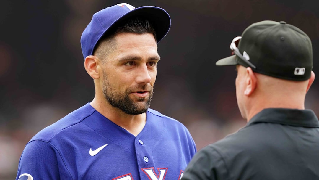 Texas Rangers pitcher Nathan Eovaldi (left) has his glove checked by umpire Scott Barry at the end of the second inning against the Baltimore Orioles at Oriole Park at Camden Yards.