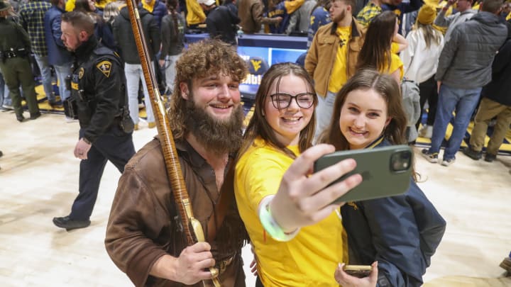 Jan 20, 2024; Morgantown, West Virginia, USA; The West Virginia Mountaineers mascot celebrates with students after defeating the Kansas Jayhawks at WVU Coliseum. Mandatory Credit: Ben Queen-USA TODAY Sports