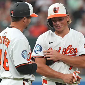 Jul 8, 2025; Baltimore, Maryland, USA; Baltimore Orioles second baseman Jackson Holliday (7) shares a moment with third base coach Buck Britton (46) at the end of the third inning against the New York Mets at Oriole Park at Camden Yards.