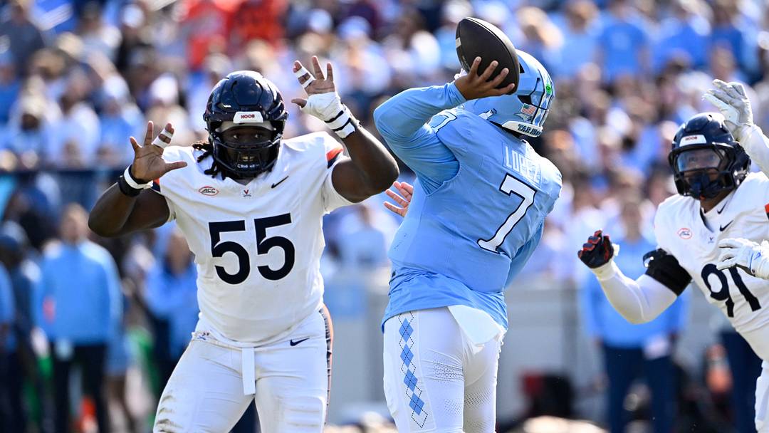 Oct 25, 2025; Chapel Hill, North Carolina, USA; North Carolina Tar Heels quarterback Gio Lopez (7) passes the ball as Virginia Cavaliers defensive tackles Anthony Britton (55) and Jason Hammond (91) pressure in the first quarter at Kenan Stadium. Mandatory Credit: Bob Donnan-Imagn Images