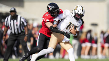 Oct 11, 2025; Cincinnati, Ohio, USA; Cincinnati Bearcats linebacker Jake Golday (11) attempts to tackle UCF Knights quarterback Cam Fancher (14) in the second half at Nippert Stadium. Mandatory Credit: Aaron Doster-Imagn Images