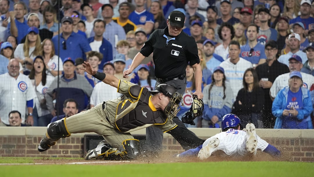 Oct 2, 2025; Chicago, Illinois, USA; San Diego Padres catcher Freddy Fermin (54) tags out Chicago Cubs second baseman Nico Hoerner (2) during the seventh inning of game three of the Wildcard round for the 2025 MLB playoffs at Wrigley Field. Mandatory Credit: David Banks-Imagn Images