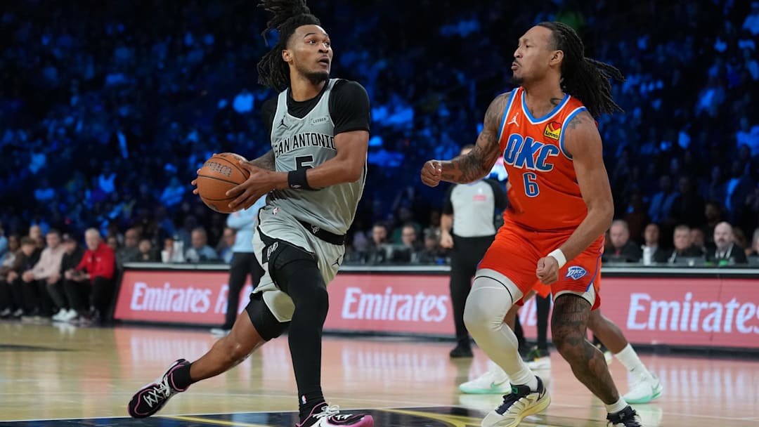 Dec 13, 2025; Las Vegas, Nevada, USA; San Antonio Spurs guard Stephon Castle (5) drives the lane on Oklahoma City Thunder forward Jaylin Williams (6) during the third quarter at T-Mobile Arena.