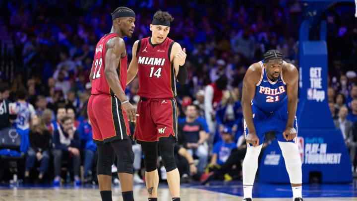 Apr 17, 2024; Philadelphia, Pennsylvania, USA; Miami Heat forward Jimmy Butler (22) and guard Tyler Herro (14) talk as Philadelphia 76ers center Joel Embiid (21) stands behind during the third quarter of a play-in game of the 2024 NBA playoffs at Wells Fargo Center. Mandatory Credit: Bill Streicher-USA TODAY Sports