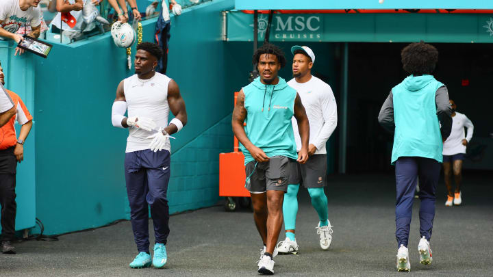 Miami Dolphins wide receiver Tyreek Hill (10) and wide receiver Jaylen Waddle (17) take on the field for warmups before a preseason game against the Washington Commanders at Hard Rock Stadium.