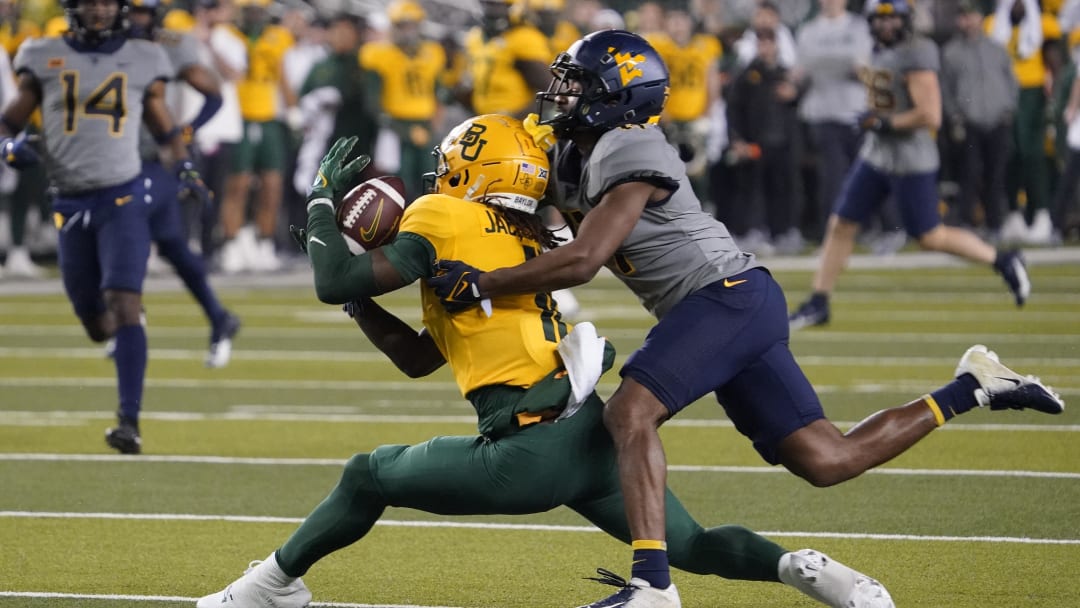 Nov 25, 2023; Waco, Texas, USA; Baylor Bears wide receiver Ketron Jackson Jr. (11) makes the catch in front of West Virginia Mountaineers cornerback Beanie Bishop Jr. (11) during the second half at McLane Stadium. Mandatory Credit: Raymond Carlin III-USA TODAY Sports