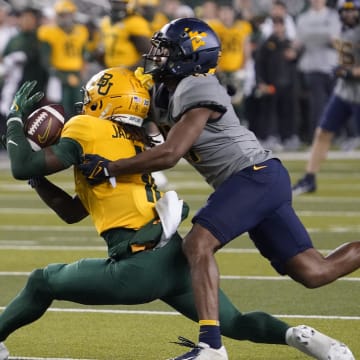 Nov 25, 2023; Waco, Texas, USA; Baylor Bears wide receiver Ketron Jackson Jr. (11) makes the catch in front of West Virginia Mountaineers cornerback Beanie Bishop Jr. (11) during the second half at McLane Stadium. Mandatory Credit: Raymond Carlin III-USA TODAY Sports