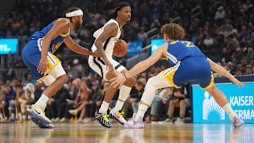 Oct 27, 2025; San Francisco, California, USA; Memphis Grizzlies guard Ja Morant (12) dribbles the ball between Golden State Warriors guard Moses Moody (4) and guard Brandin Podziemski (2) in the second quarter at the Chase Center. Mandatory Credit: Cary Edmondson-Imagn Images