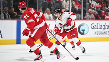 Apr 4, 2025; Detroit, Michigan, USA; Carolina Hurricanes center Justin Robidas (46) brings the puck up ice against Detroit Red Wings center Dylan Larkin (71) during the first period at Little Caesars Arena. Mandatory Credit: Tim Fuller-Imagn Images