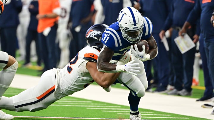 Aug 11, 2024; Indianapolis, Indiana, USA;  Indianapolis Colts running back Tyler Goodson (31) is tackled by Denver Broncos linebacker Jonah Elliss (52) during the first quarter at Lucas Oil Stadium. 