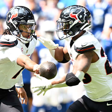 Sep 8, 2024; Indianapolis, Indiana, USA; Houston Texans quarterback C.J. Stroud (7) hands the ball off to Houston Texans running back Joe Mixon (28) during the second quarter at Lucas Oil Stadium. Mandatory Credit: Marc Lebryk-Imagn Images