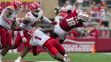 Sep 20, 2025; Madison, Wisconsin, USA;  Wisconsin Badgers quarterback Danny O'Neil (18) is tackled by Maryland Terrapins linebacker Daniel Wingate (1) during the third quarter at Camp Randall Stadium. Mandatory Credit: Jeff Hanisch-Imagn Images