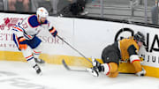 May 8, 2025; Las Vegas, Nevada, USA; Vegas Golden Knights defenseman Brayden McNabb (3) impacts the boards after being tripped by Edmonton Oilers left wing Viktor Arvidsson (33) during an overtime period of game two of the second round of the 2025 Stanley Cup Playoffs at T-Mobile Arena. Mandatory Credit: Stephen R. Sylvanie-Imagn Images