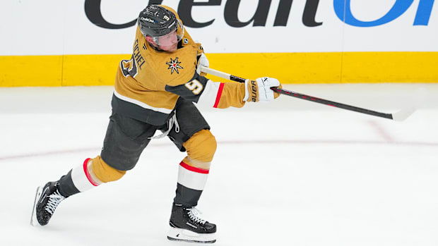 Hockey player in gold uniform shoots the puc