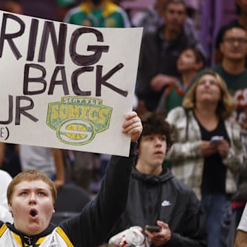 A fan pleads for the SuperSonics to return before a 2023 exhibition game between the Clippers and Jazz in Seattle.