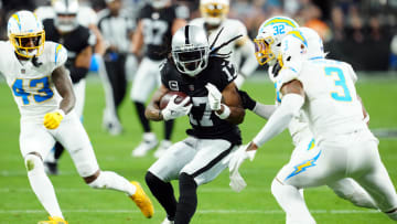 Dec 14, 2023; Paradise, Nevada, USA; Las Vegas Raiders wide receiver Davante Adams (17) runs against Los Angeles Chargers safety Alohi Gilman (32) and safety Derwin James Jr. (3) in the first quarter at Allegiant Stadium. Mandatory Credit: Stephen R. Sylvanie-USA TODAY Sports