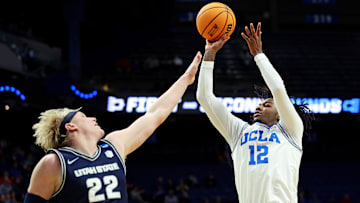 Mar 20, 2025; Lexington, KY, USA;  UCLA Bruins guard Sebastian Mack (12) shoots the ball against Utah State Aggies forward Karson Templin (22) during the second half in the first round of the NCAA Tournament at Rupp Arena. Mandatory Credit: Jordan Prather-Imagn Images