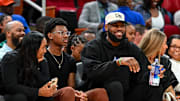 Mar 28, 2023; Houston, TX, USA; Los Angeles Lakers forward LeBron James sits with his wife Savannah James (right), son Bryce Maximus James (left) and his mother Gloria Marie James (left) court side of the between the McDonald's All American East and the McDonald's All American West at Toyota Center. Mandatory Credit: Maria Lysaker-Imagn Images