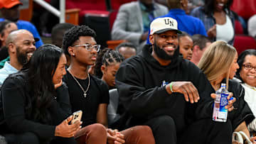 Mar 28, 2023; Houston, TX, USA; Los Angeles Lakers forward LeBron James sits with his wife Savannah James (right), son Bryce Maximus James (left) and his mother Gloria Marie James (left) court side of the between the McDonald's All American East and the McDonald's All American West at Toyota Center. Mandatory Credit: Maria Lysaker-Imagn Images