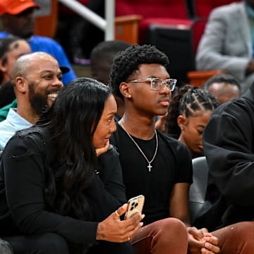 Mar 28, 2023; Houston, TX, USA; Los Angeles Lakers forward LeBron James sits with his wife Savannah James (right), son Bryce Maximus James (left) and his mother Gloria Marie James (left) court side of the between the McDonald's All American East and the McDonald's All American West at Toyota Center. Mandatory Credit: Maria Lysaker-Imagn Images