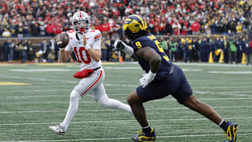 Nov 29, 2025; Ann Arbor, Michigan, USA; Ohio State Buckeyes quarterback Julian Sayin (10) runs the ball pressured by Michigan Wolverines defensive end Cameron Brandt (9) in the first half at Michigan Stadium. Mandatory Credit: Rick Osentoski-Imagn Images