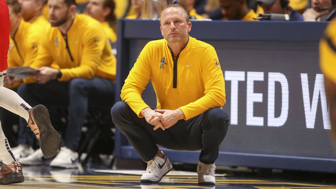 Jan 7, 2025; Morgantown, West Virginia, USA; West Virginia Mountaineers head coach Darian DeVries watches from the sidelines during the first half against the Arizona Wildcats at WVU Coliseum. Mandatory Credit: Ben Queen-Imagn Images