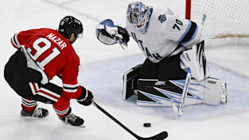 Mar 30, 2025; Chicago, Illinois, USA;  Chicago Blackhawks center Frank Nazar (91) shoots against Utah Hockey Club goaltender Karel Vejmelka (70) during the second period at United Center. Mandatory Credit: Matt Marton-Imagn Images