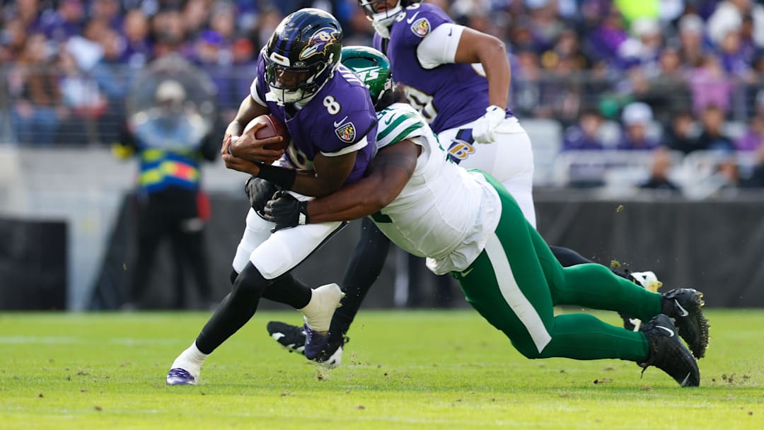 Nov 23, 2025; Baltimore, Maryland, USA; Baltimore Ravens quarterback Lamar Jackson (8) rushes and is tackled by New York Jets defensive tackle Jowon Briggs (91) during the second quarter at M&T Bank Stadium. Mandatory Credit: Peter Casey-Imagn Images