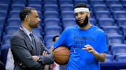 Mar 26, 2024; New Orleans, Louisiana, USA; Trajan Langdon, the general manager of the New Orleans Pelicans, left, talks with  Oklahoma City Thunder forward Kenrich Williams (34) before a game at Smoothie King Center. Mandatory Credit: Matthew Hinton-Imagn Images