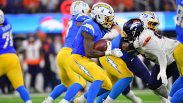 Dec 19, 2024; Inglewood, California, USA; Los Angeles Chargers running back Gus Edwards (4) runs the ball against the Denver Broncos during the first half at SoFi Stadium. Mandatory Credit: Gary A. Vasquez-Imagn Images