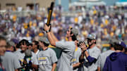 Jun 22, 2025; Omaha, Neb, USA;  LSU Tigers pitcher Chase Shores (34) holds up the championship trophy after the win against the Coastal Carolina Chanticleers at Charles Schwab Field. Mandatory Credit: Steven Branscombe-Imagn Images