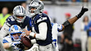 Dallas Cowboys quarterback Dak Prescott is pressured by Detroit Lions Al-Quadin Muhammad and Aidan Hutchinson.