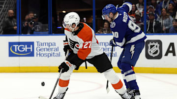 Mar 17, 2025; Tampa, Florida, USA;  Philadelphia Flyers left wing Noah Cates (27) skates with the puck as Tampa Bay Lightning defenseman J.J. Moser (90) defends during the second period at Amalie Arena. Mandatory Credit: Kim Klement Neitzel-Imagn Images